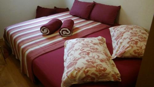 a bed with three pillows on top of it at Apartmani Lea in Jadranovo