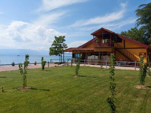 a house on the beach with a grassy yard at Villa art colony in Ohrid
