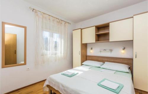 1 dormitorio con 1 cama blanca grande y espejo en Apartmani Štampar, en Cesarica