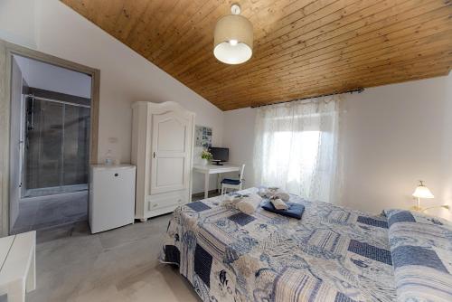 a room with a bed, a refrigerator, and a window at Casa Lucia in Olbia
