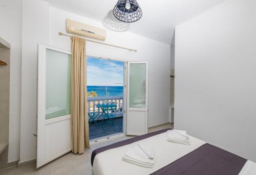 a bedroom with a bed and a view of the ocean at Aislin House in Kamari