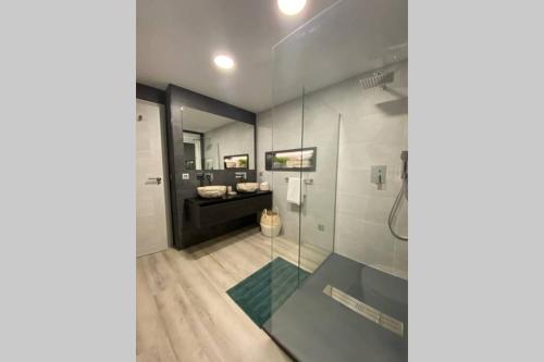 Un baño con ducha de cristal y lavabo. en PRECIOSO APARTAMENTO A ESTRENAR EN CENTRO DE NERJA, en Nerja