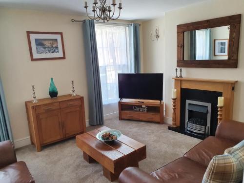 a living room with a television and a fireplace at Ty Dre Town House in Caernarfon