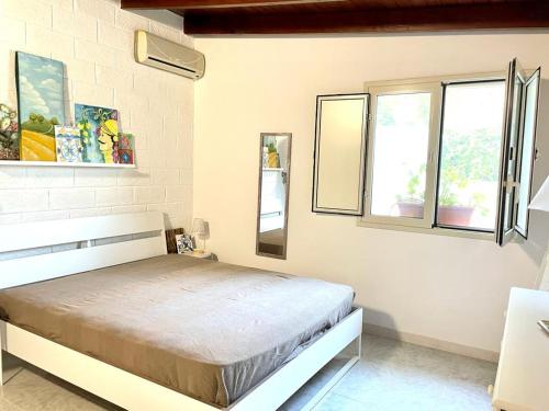 a bedroom with a bed and two windows at Casa Alice a 100 mt dal mare, free wi-fi in Porto Palo