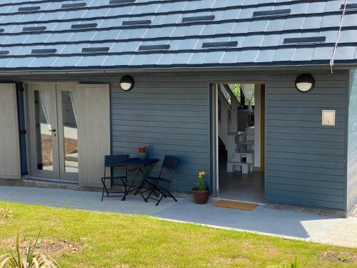 a blue house with a table and chairs on a patio at Apartment I&M in Plitvička Jezera