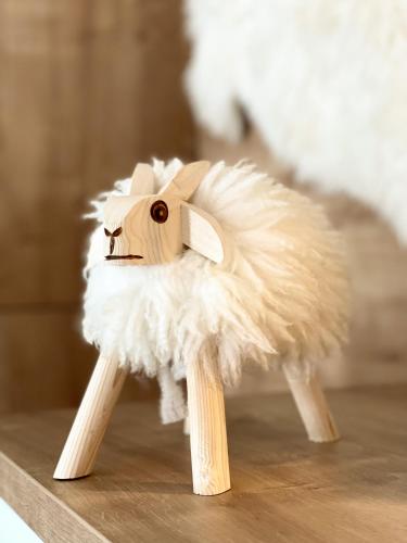 a wooden toy goat sitting on a wooden table at Apartmán Vila Zuberec in Zuberec
