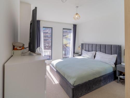 1 dormitorio con 1 cama, TV y ventana en Pass the Keys Modern Balcony Apartment in the heart of Stratford en Londres