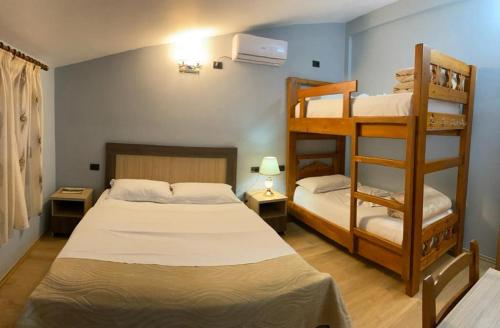 a bedroom with two bunk beds and a ladder at Joan Guesthouse in Përmet