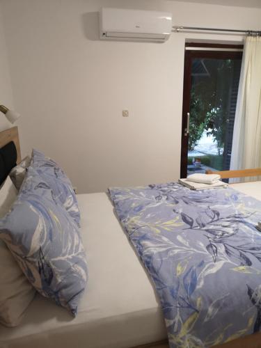 - un lit avec une couette bleue et une fenêtre dans l'établissement Meje Apartments, à Split