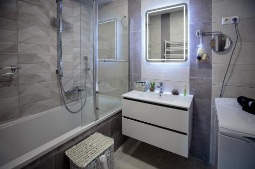 a bathroom with a white sink and a shower at Mokka Apartments in Miskolc