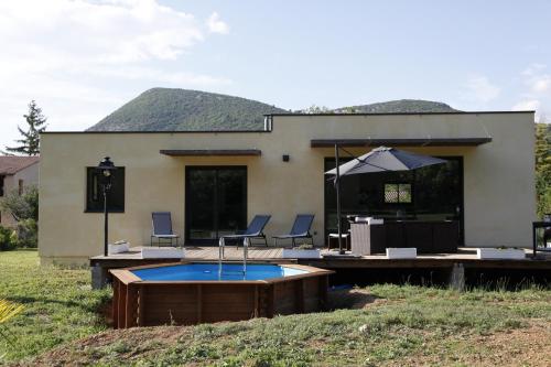 ein Haus mit einem Whirlpool und Stühlen im Hof in der Unterkunft Villa en Campagne Provençale avec piscine in Curnier