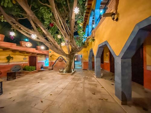 una habitación con un árbol en el medio de un edificio en Hotel Boutique Santo Cuervo, en Bernal