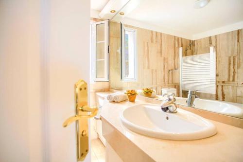 a white bathroom with a sink and a tub at El Veril 84 Bahia del Duque in Adeje