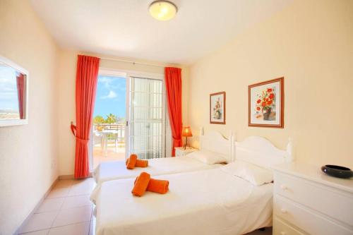 two white beds in a room with a window at El Veril 84 Bahia del Duque in Adeje