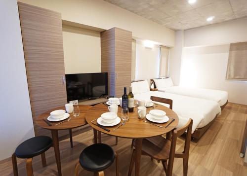 a room with a table and chairs and a bed at Prime Suites Tokyo in Tokyo