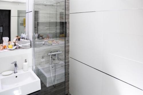Baño blanco con lavabo y espejo en Apartment,private parking, balcony, smart check in, en Banská Bystrica