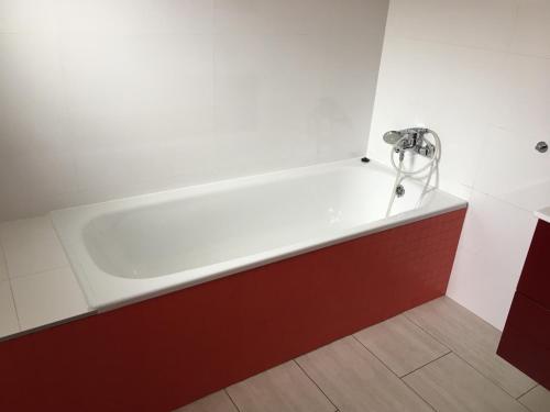 a bath tub in a bathroom with a red and white wall at River wellness in Jince