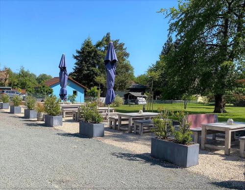 a row of picnic tables with umbrellas in a park at Hotel Maurer in Saarwellingen