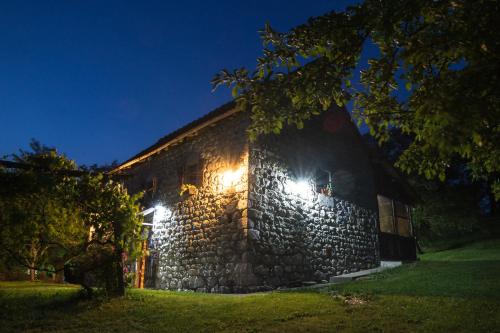 a stone building with lights on it at night at Djurdjevina Family Farm in Kolašin