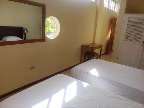 a bedroom with a white bed and a mirror at Sea Shell Palms, Ocho Rios in Ocho Rios
