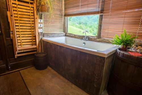 a bath tub in a room with a window at Djurdjevina Family Farm in Kolašin