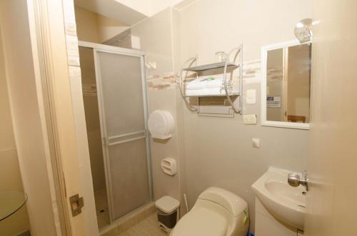 a white bathroom with a toilet and a sink at Hotel Piura Sol de Grau in Piura