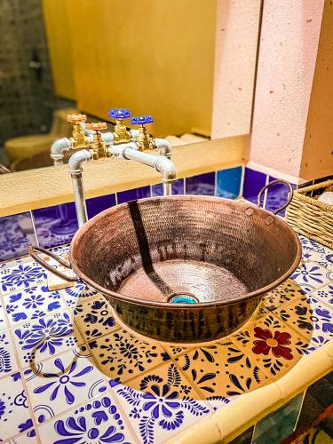 a bathroom sink with a copper bowl on a counter at Hotel Boutique Santo Cuervo in Bernal