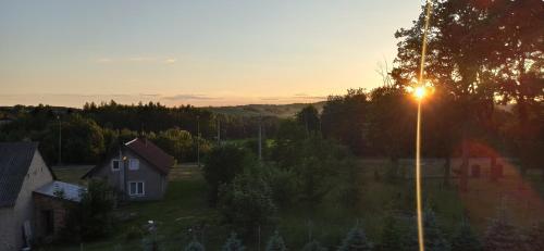 a house and a street light at sunset at Agroturystyka Pokój na Skarpie in Kowale Oleckie