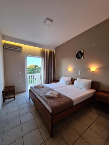 una camera con un grande letto e una grande finestra di Abella Hotel ad Agia Marina Nea Kydonias