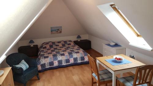 1 dormitorio con cama y mesa en el ático en Ferien auf zwei Ebenen in der Möwenkoje, en Grömitz