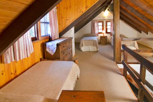 Schlafzimmer im Dachgeschoss mit 2 Betten in einer Hütte in der Unterkunft Samai Suma Cabañas & Spa in Villa General Belgrano
