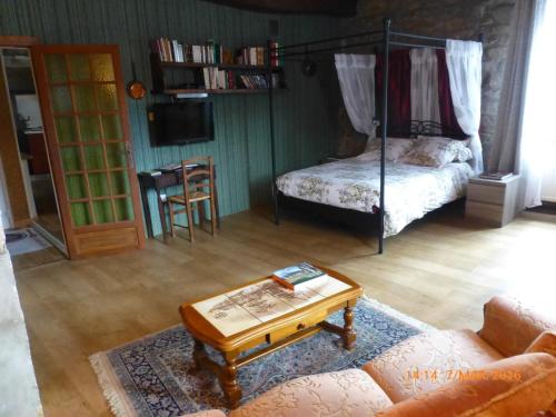 uma sala de estar com uma cama e uma mesa de centro em Le Logis de la Cour de Bretagne au Port de Dinan Lanvallay em Lanvallay
