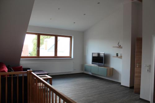 uma sala de estar vazia com uma televisão e uma janela em FeWo Krämer em Plein