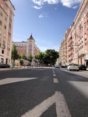 an empty city street with buildings and cars on the road at Lisbon Top Hostel in Lisbon