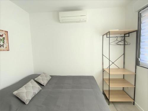 een slaapkamer met een bed en een boekenplank bij Appartement vue mer panoramique près de Porticcio in Pietrosella