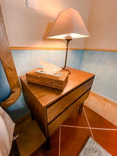 a table with a lamp and a basket on it at Hotel Boutique Santo Cuervo in Bernal