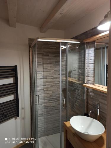 een badkamer met een glazen douche en een wastafel bij Botte Verticale Civ.80 in Santa Maria di Piave