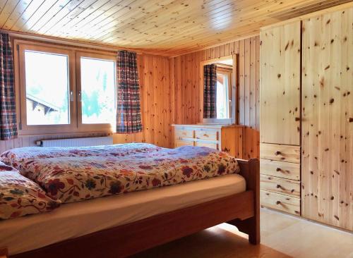 ein Schlafzimmer mit einem Bett in einer Holzhütte in der Unterkunft Haus Diezig in Blitzingen
