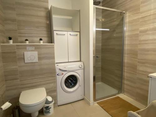 een badkamer met een toilet en een wasmachine bij Appartement vue mer panoramique près de Porticcio in Pietrosella