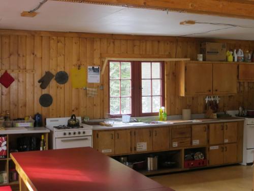 HI Rampart Creek - Hostel في ساسكاتشيوان ريفر كروسينج: مطبخ فيه دواليب خشبية ونافذة