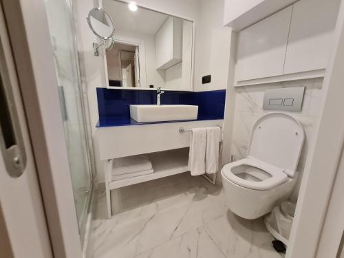 a bathroom with a white toilet and a sink at Hotel Orbi City Sea Horizon in Batumi