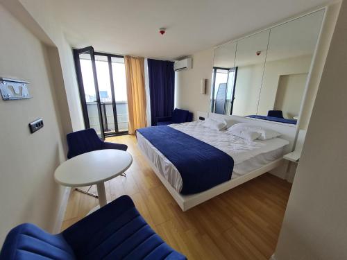 1 dormitorio con 1 cama, mesa y sillas en Hotel Orbi City Sea Horizon, en Batumi