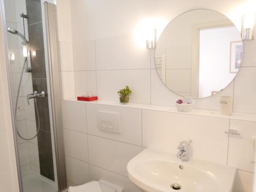 a white bathroom with a sink and a mirror at Pension Helma in Bad Neuenahr-Ahrweiler