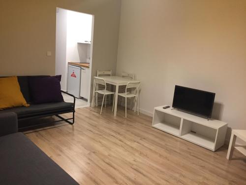 華沙的住宿－Studio Apartment，客厅配有沙发和桌子上的电视