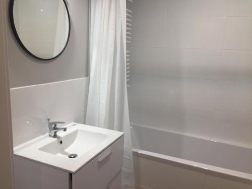 華沙的住宿－Studio Apartment，白色的浴室设有水槽和镜子