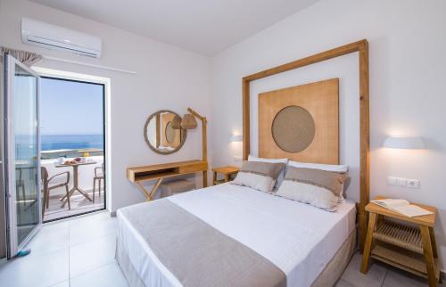 a bedroom with a bed and a view of the ocean at Eleana Nature & Art in Khóra Sfakíon