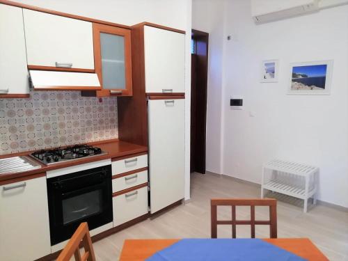 een keuken met een fornuis en een witte koelkast bij via Ancona a 50mt dal mare in Marcelli