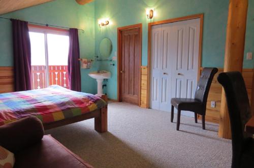 a bedroom with a bed and a chair and a window at Tschurtschenthaler Lodge in Golden