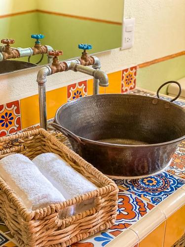 a bathroom sink with a basket and a copper tub at Hotel Boutique Santo Cuervo in Bernal