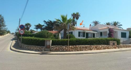 eine Straße mit Häusern und einer Steinmauer in der Unterkunft Ferienhaus nahe am Meer in Sant Lluís